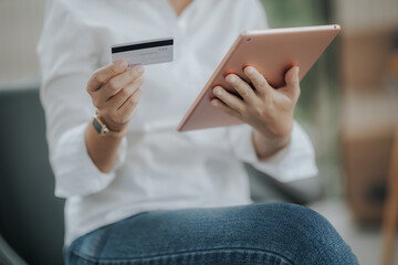 Portrait of young Asian woman paying online using touchpad While in the cafe