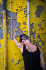 Una donna disperata piange appoggiata ad un muro giallo rovinato a Burano, isola della laguna di...