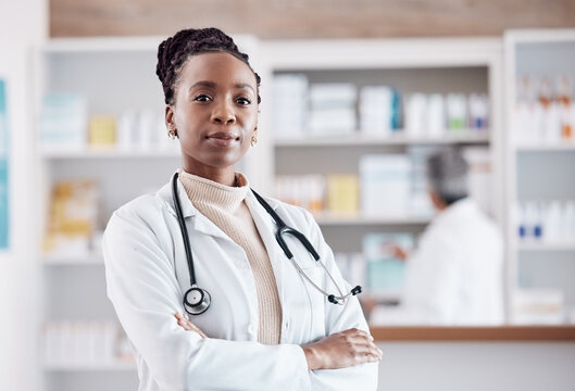 Pharmacy, pharmacist or portrait of black woman with arms crossed in healthcare clinic or drugstore. Proud nurse, wellness or confident African doctor by medication or medicine on shelf ready to help