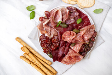 Food aperitif Italian prosciutto ham, parma ham, salami, bresaola beef olives and grissini breadstick. Charcuterie plate