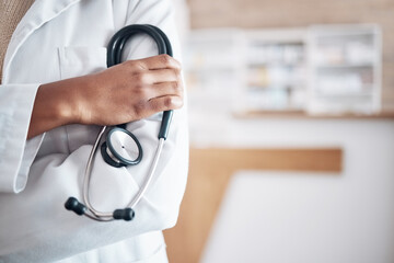 Hands, doctor and arms crossed with stethoscope in hospital, surgery and trust. Closeup of medical worker, cardiology expert and with cardiovascular tools for healthcare services, consulting and test