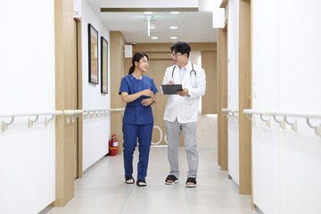 병원 복도에서 의료진이 걸어가면서 회의하는 모습