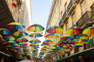 Fototapeta na wymiar Colored umbrellas are hanging over city street