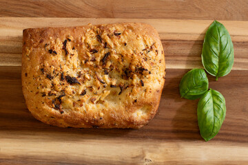 Homemade cheese and onion Italian, with olives and rosemary flatbread, focaccia on a wooden surface. It is leavened and oven-baked. Top view.