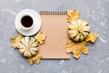 Autumn composition: fallen leaves and craft sketchbook mock up on colored background. Top view. Flat lay with copy space