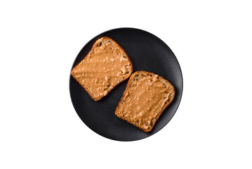 Nutritious sandwich consisting of bread and peanut butter on a black ceramic plate
