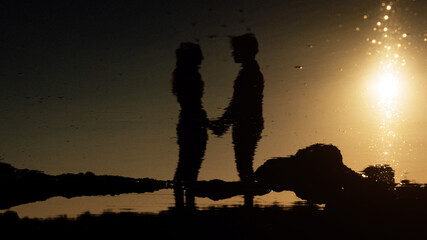 Reflet de la silhouette d'un couple de deux personnes dans l'eau