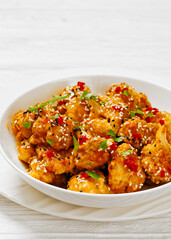 crispy orange cauliflower florets in white bowl