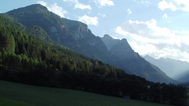 Mountains in Austria at the Brenner Pass at dusk with meadows and forests in 4k