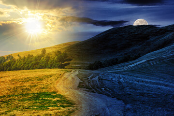 early autumn mountain landscape with path through the hillside with sun and moon at twilight. day and night time change concept. mysterious countryside scenery in morning light