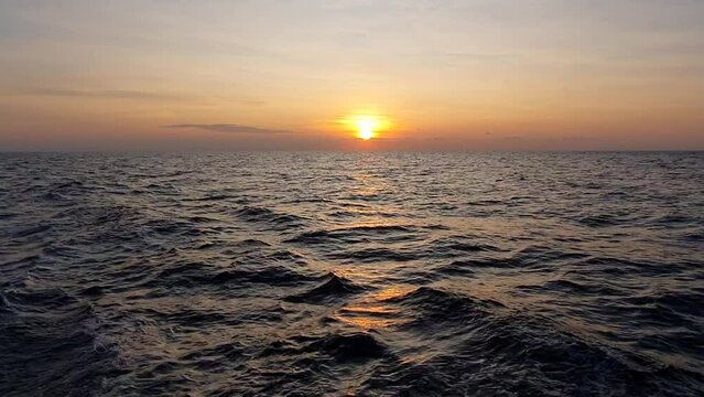 sunset over the sea, seen from inside the running boat