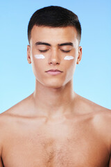 Naklejka premium Self care, skincare or man with face cream product for beauty or natural moisturizer or cosmetics in studio. Blue background, eyes closed or model with facial creme or dermatology lotion for glow