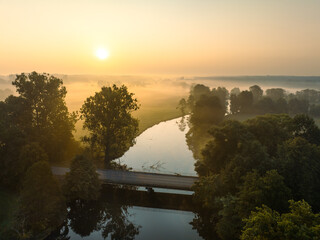 Mglisty poranek nad rzeką o wschodzie słońca  