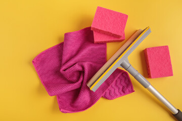 Set for cleaning windows and other surfaces on yellow background. Cleaning concept, professional cleaning, household supplies. Top view, flat lay with free copy space