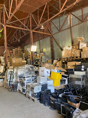 Sorting electronic waste for recycling. Cell phone photo of a warehouse.