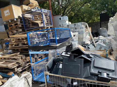 Sorting electronic waste for recycling. Cell phone photo of a warehouse.