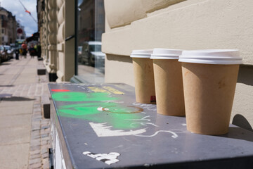 Fototapeta na wymiar Cardboard cups of hot drinks, abandoned on the street without recycling.