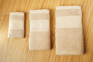 a stack of folded towels on a wooden shelf with a ladder in the background towels on wooden in bath
