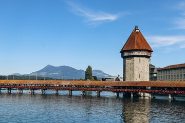 Fototapeta na wymiar The Kapellbrucke (literally, Chapel Bridge), a covered wooden footbridge spanning the river Reuss diagonally in the city of Lucerne in central Switzerland