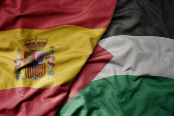 big waving national colorful flag of spain and national flag of palestine .