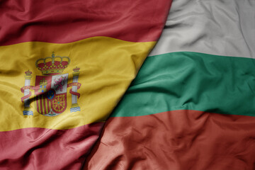 big waving national colorful flag of spain and national flag of bulgaria .
