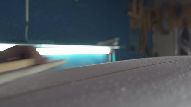 Male surfboard shaper making surfboard in his workshop. Hand shaping from blank.