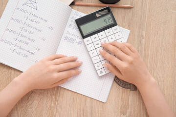 Woman working with calculator on wooden table, closeup