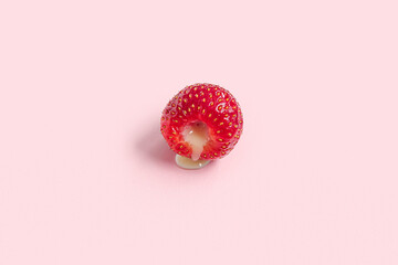 Fresh strawberry with liquid on pink background. closeup. Sex education concept