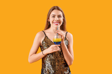 Beautiful young woman with glass of tasty cocktail on yellow background