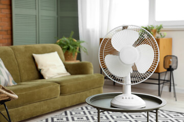 Electric fan on coffee table in living room, closeup