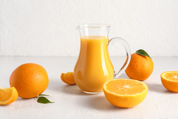 Jug of fresh orange juice on white background