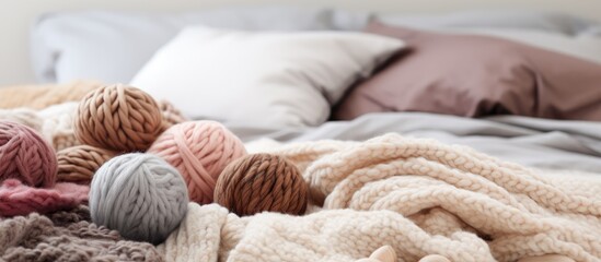 Yarn balls and a wool blanket on the bedspread - obrazy, fototapety, plakaty