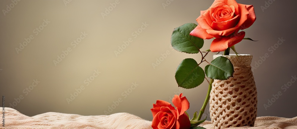 Aufkleber Blurred background with a knitted element and a rose in a vase