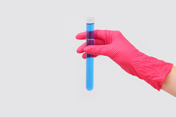 Lab's worker hand with test tube of sample on grey background