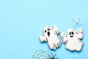 Tasty cookies in shape of ghost and web for Halloween celebration on blue background