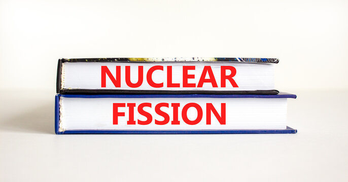 Nuclear fission symbol. Concept words Nuclear fission on beautiful books. Beautiful white table white background. Business science nuclear fission concept. Copy space.