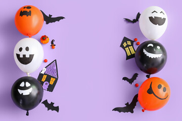 Different funny Halloween balloons with party decorations on lilac background