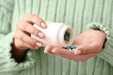 Woman holding jar with different pills, closeup