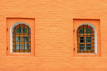 Fototapeta na wymiar Windows with a powerful iron lattice in a brick wall