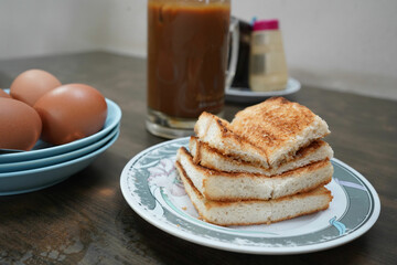 Kaya toast with a side of eggs and a cup of iced kopi - singapore