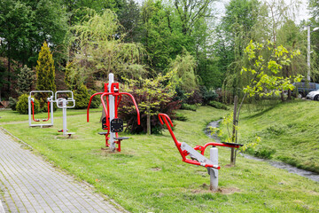 ROKICINY PODHALANSKIE, POLAND - MAY 26, 2023: An outdoor gym among bushes, near a river that flows rapidly.