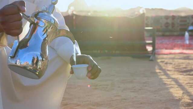 Saudi Arabia arabic man with traditional clothing preparing arabic coffee in the desert of Al Ula with white clothing