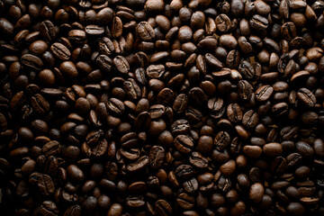 Horizontal view of halves of dark brown coffee beans with pleasant scent. Copy space
