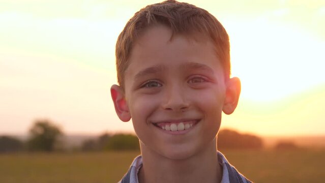 kid face. A cute, handsome boy is smiling. sunlight falls on the face