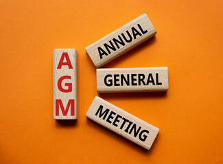 AGM - Annual general meeting symbol. Concept word AGM on wooden cubes. Beautiful orange background. Business and AGM concept. Copy space.