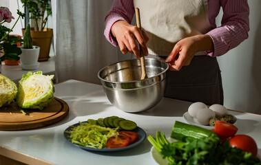 Woman prepares a vegetable salad in the kitchen