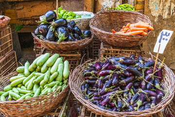 Eggplants, squash, and carrots at an outdoor market.