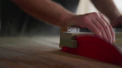 Close-up of sawing machine trimming piece of wood at carpentry workshop