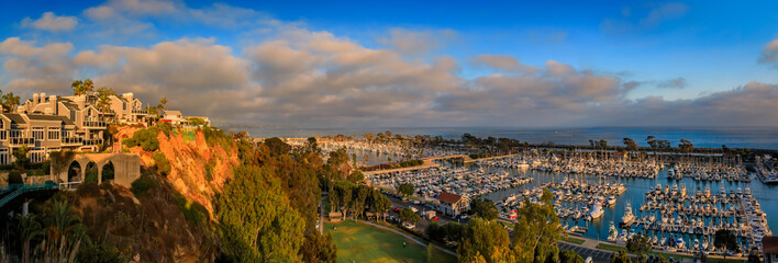 Sunset over luxury homes, yachts, and boats in Dana Point harbor, Orange County in Southern...
