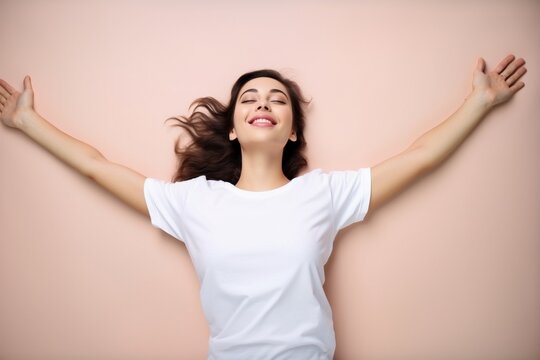 woman lying down on back wearing white t-shirt on pick background for mockup
